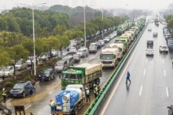 湖北省武汉市为收治新型冠状病毒感染的病人而建造新医院，多辆卡车给医院工地运送建筑材料。（2020年1月24日）