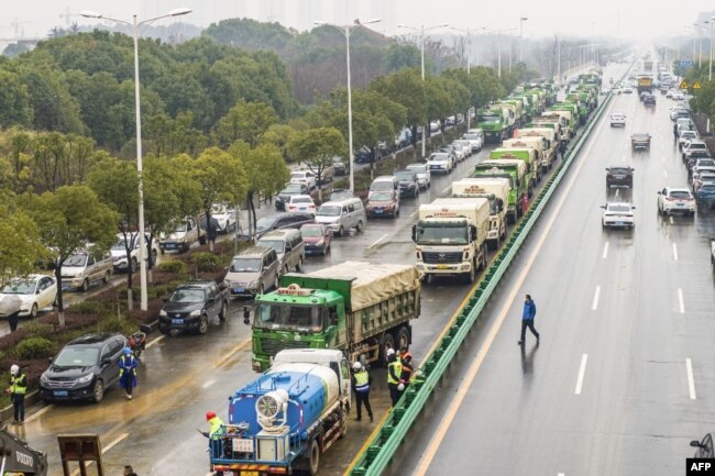湖北省武汉市为收治新型冠状病毒感染的病人而建造新医院，多辆卡车给医院工地运送建筑材料。（2020年1月24日）