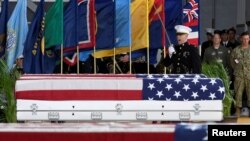 FILE - An honor guard signals a command as caskets containing the remains of American servicemen from the Korean War handed over by North Korea arrive at Joint Base Pearl Harbor-Hickam in Honolulu, Hawaii, U.S., Aug. 1, 2018.