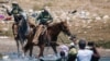 US Customs and Border Protection mounted officers attempt to contain migrants as they cross the Rio Grande from Ciudad Acuña, Mexico, into Del Rio, Texas, Sept. 19, 2021.