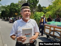 Pengurus Jemaat Ahmadiyah Indonesia (JAI) Bandung Tengah, Mansyur Ahmad, memegang buku "Haqiqatul Wahy" yang didiskusikan. Buku tersebut selesai diterjemahkan ke bahasa Indonesia dan terbit Juli 2018. (Foto: VOA/Rio Tuasikal)