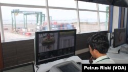 Pengoperasian peralatan bongkar muat peti kemas dengan crane bertenaga listrik dan dikendalikan operator dari ruang kontrol di Terminal Teluk Lamong Surabaya (VOA/Petrus Riski)