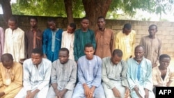 Police officers present suspected Boko Haram militants in Maiduguri, northest Nigeria, on July 18, 2018.