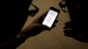 2013年9月11日蘋果公司員工在中國北京向記者介紹iPhone 5S內置指紋掃描技術。