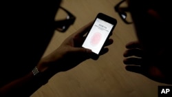 2013年9月11日苹果公司员工在中国北京向记者介绍iPhone 5S内置指纹扫描技术。