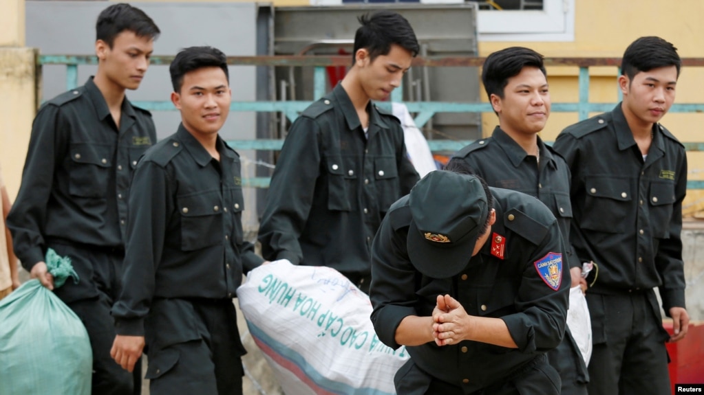 Một cảnh sát lạy tạ dân làng Đồng Tâm sau khi được phóng thích hôm 22 tháng Tư. (REUTERS/Kham)