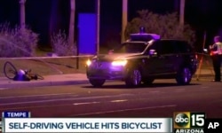 This March 19, 2018 still image taken from video provided by ABC-15, shows investigators at the scene of a fatal accident involving a self driving Uber car on the street in Tempe, Ariz. (ABC-15.com via AP)