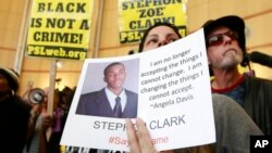 活動人士手舉被打死的非洲裔美國人克拉克的照片