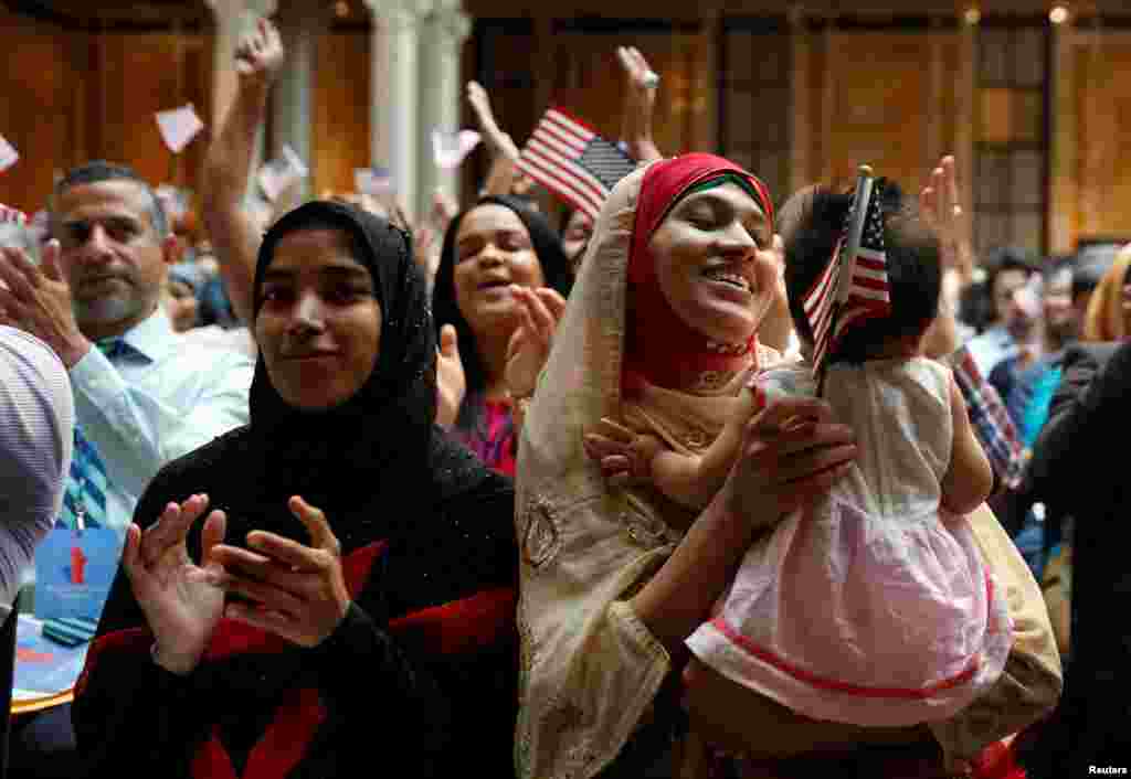 New citizens smile at a U.S. Citizenship and Immigration Services (USCIS) naturalization ceremony at the New York Public Library in Manhattan, New York, July 3, 2018.