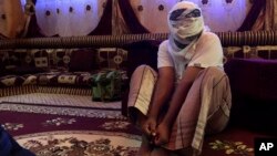 A former detainee shows how he was kept in handcuffs and leg shackles while held in a secret prison at Riyan airport in the Yemeni city of Mukalla, May 11, 2017.