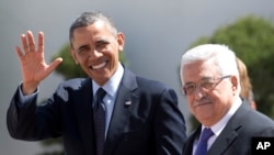 Prezidan Barack Obama ap salye repòtè yo pandan lap mache bò kote Prezidan Palestinyen an, Mahmoud Abbas (adwat) nan moman li tap rive nan Palè Mouqata, nan vil Ramallah, Si-Jòdani (21 mas 2013). 