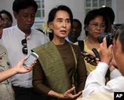 FILE - Myanmar's opposition leader Aung San Suu Kyi talks to journalists during a press briefing in Yangon, Jan. 2, 2014.