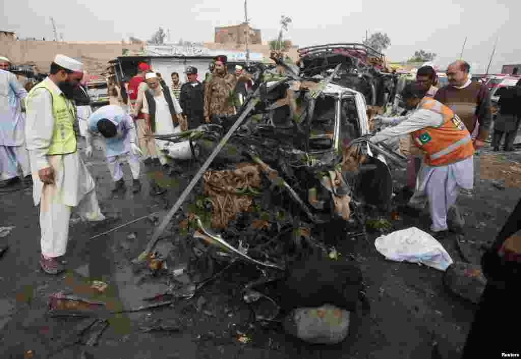 Rescue workers collect body parts after a bomb attack at Fauji Market in Peshawar December 17, 2012. The blast in the market in northwest Pakistan on Monday killed at least 15 people, a security official said. The official said at least 20 people had been