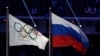 FILE - In this Feb. 23, 2014, photo, the Russian national flag, right, flies next to the Olympic flag during the closing ceremony of the 2014 Winter Olympics in Sochi, Russia.