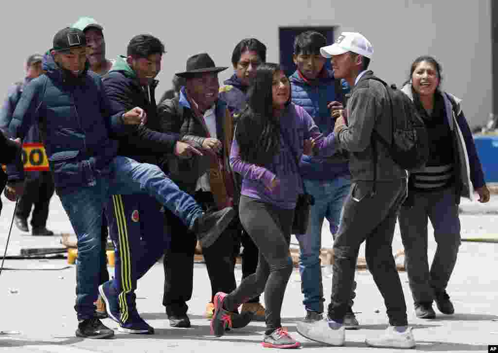 A woman is kicked by a member of a group of President Evo Morales' followers in La Paz, Bolivia.