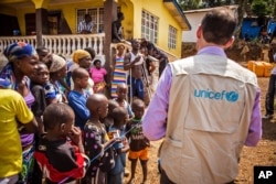 FILE - A UNICEF aid worker visits a home in Freetown, Sierra Leone.