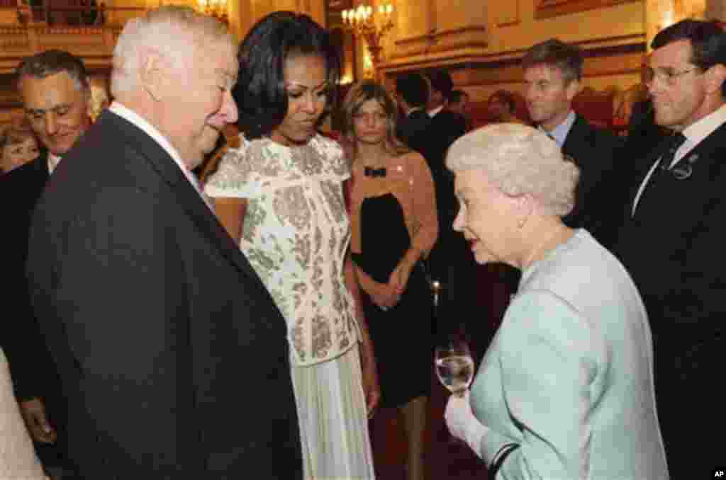 Britain's Queen Elizabeth II talks with U.S. first lady Michelle Obama and US Ambassador Louis Susman at Buckingham Palace in London for a reception hosted by Queen Elizabeth II for the heads of state and government prior to attending the opening ceremony