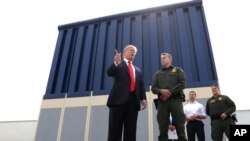 El presidente Donald Trump habla durante una revisión de los prototipos para el muro fronterizo en San Diego, mientras Rodney Scott, lo escucha. Foto de archivo.