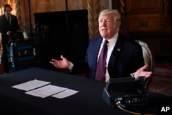 FILE - President Donald Trump speaks to reporters following his teleconference with troops from his Mar-a-Lago estate in Palm Beach, Florida, Nov. 22, 2018.