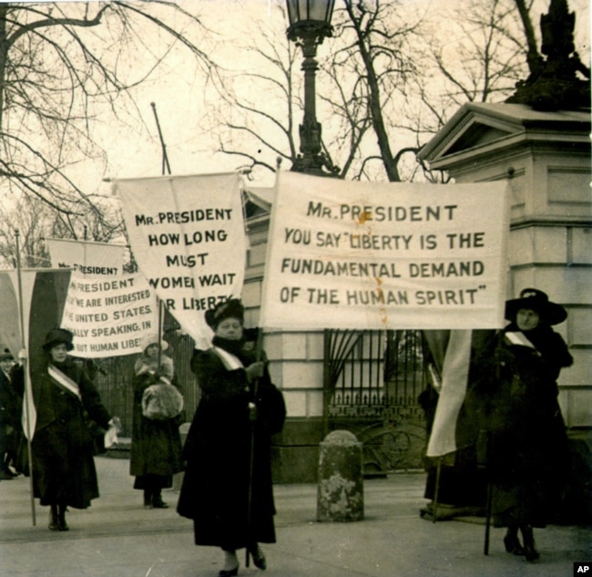 FILE - In this circa 1918 photo women demonstrate at the White House in Washington demanding voting rights.