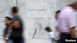 People walk past the Bank of Greece in Athens, June 19, 2015.