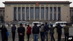 People watch as police officers check visitors in front of the Great Hall of the People during a gathering of the 205-member Central Committee's third annual plenum in Beijing, China, Nov. 9, 2013.
