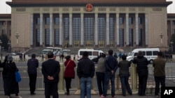 北京天安门广场上的人们观察警察在人民大会堂检查访问者（2013年11月9日）