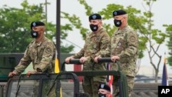 FILE - Incoming commander, Gen. Paul J. LaCamera, right, and outgoing commander, Gen. Robert B. Abrams, center, during a change-of-command ceremony at Barker Field in Pyeongtaek, South Korea, July 2, 2021.