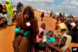 FILE - Somali refugees walk through an area housing new arrivals, on the outskirts of Hagadera Camp outside Dadaab, Kenya.