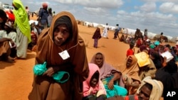 FILE - Somali refugees walk through an area housing new arrivals, on the outskirts of Hagadera Camp outside Dadaab, Kenya, Aug. 5, 2011. Residents of a new "integrated" settlement at Kalobeyei, in the country's northeast, complain that living conditions are not as they expected them to be.