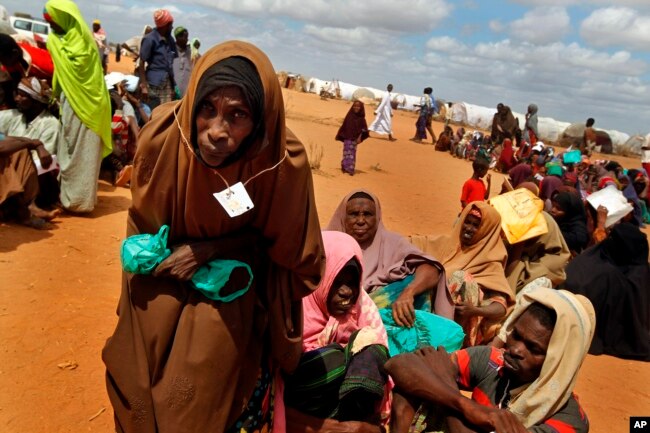 FILE - Somali refugees walk through an area housing new arrivals, on the outskirts of Hagadera Camp outside Dadaab, Kenya.