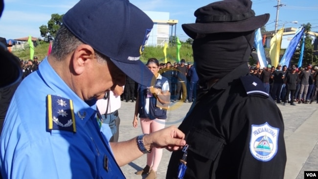 Uno de los soldados nicaragüenses encapuchados recibe la condecoración impuesta por un superior. Foto cortesía de la policía de Nicaragua.