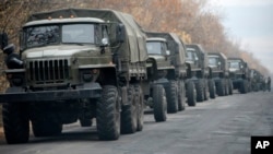 Unmarked military vehicles are parked on a road outside the separatist rebel-held eastern Ukrainian town of Snizhne, 80 kilometers from Donetsk, Nov. 8, 2014. 