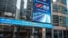 FILE - People walk beneath a welcome message for Chinese artificial intelligence startup SenseTime after its listing on the stock exchange in Hong Kong, Dec. 30, 2021.