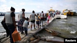 En Necoclí, Colombia, migrantes, en su mayoría haitianos, abordan un bote con destino a Acandí, para luego cruzar a Panamá y continuar hacia el norte, el 23 de septiembre de 2021. Otros han tomado el camino de regreso a países de Latinoamérica. 