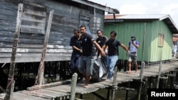 Villagers carry the body of a dead gunmen that was killed on Saturday, Simunul village in Sabah's Semporna district, March 4, 2013. 