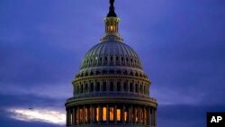 La luz en la cúpula del Capitolio en Washington está iluminada en indicación de que el Congreso se mantiene en la bores el 6 de octubre de 2021. 