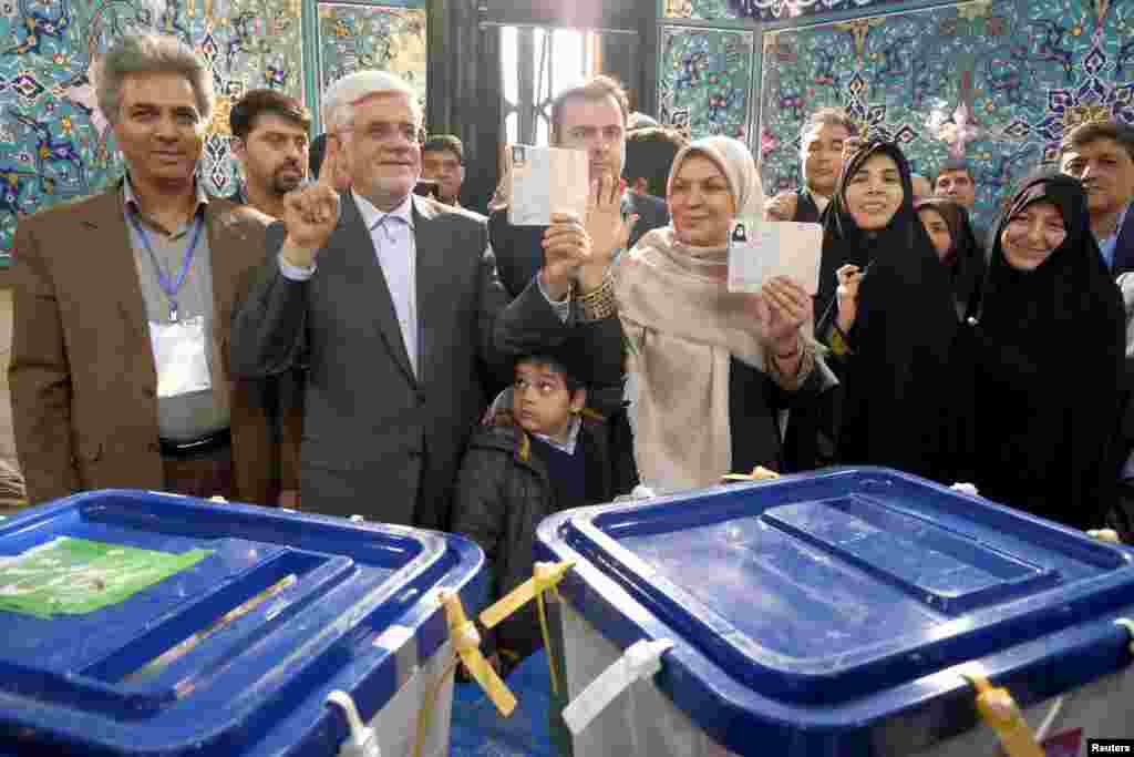 Iranian former vice president and candidate for parliamentary election Mohammad Reza Aref and his wife show their ink-stained fingers after casting their ballots during elections for the parliament and Assembly of Experts, in Tehran, Feb. 26, 2016.