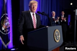 FILE - U.S. President Donald Trump is applauded by Vice President Mike Pence and House Speaker Paul Ryan as he arrives to speak at a congressional Republican retreat in Philadelphia, Jan. 26, 2017.