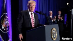 FILE - U.S. President Donald Trump is applauded by Vice President Mike Pence and House Speaker Paul Ryan as he arrives to speak at a congressional Republican retreat in Philadelphia, Jan. 26, 2017.