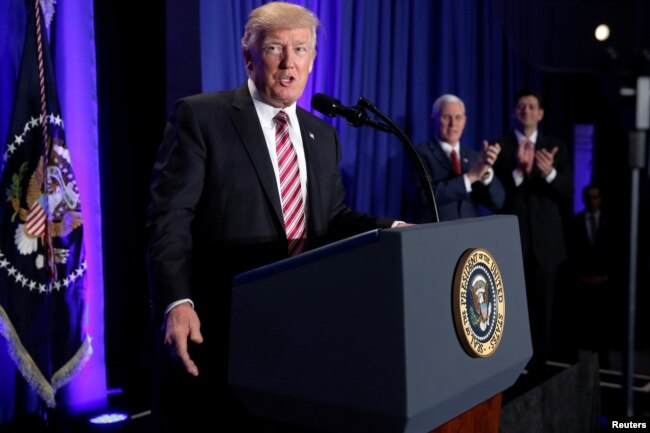 FILE - U.S. President Donald Trump is applauded by Vice President Mike Pence and House Speaker Paul Ryan as he arrives to speak at a congressional Republican retreat in Philadelphia, Jan. 26, 2017.