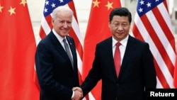 រូបឯកសារ៖ ប្រធានាធិបតី​ចិន​លោក Xi Jinping ចាប់ដៃ​ជាមួយ​លោក Joe Biden នៅ​ពេល​ដែល​លោក​នៅ​ជា​អនុ​ប្រធានាធិបតី​អាមេរិក នៅខាង​ក្នុង​មហាសាល​ប្រជាជន​ក្នុង​ទីក្រុង​ប៉េកាំង កាលពី​ថ្ងៃទី៤ ខែធ្នូ ឆ្នាំ២០១៣។