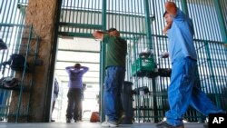 Presuntos inmigrantes ilegales son procesados en el sector Tucson de la sede de la agencia de Aduanas y Protección Fronteriza en Tucson, Ariz. Agosto 9, 2012.