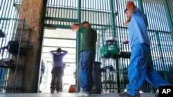 Presuntos inmigrantes ilegales son procesados en el sector Tucson de la sede de la agencia de Aduanas y Protección Fronteriza en Tucson, Ariz. Agosto 9, 2012.