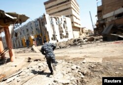 Iraqi Federal Police take cover during a battle with Islamic State fighters at Bab al-Jadid district in the old city of Mosul, March 26, 2017.