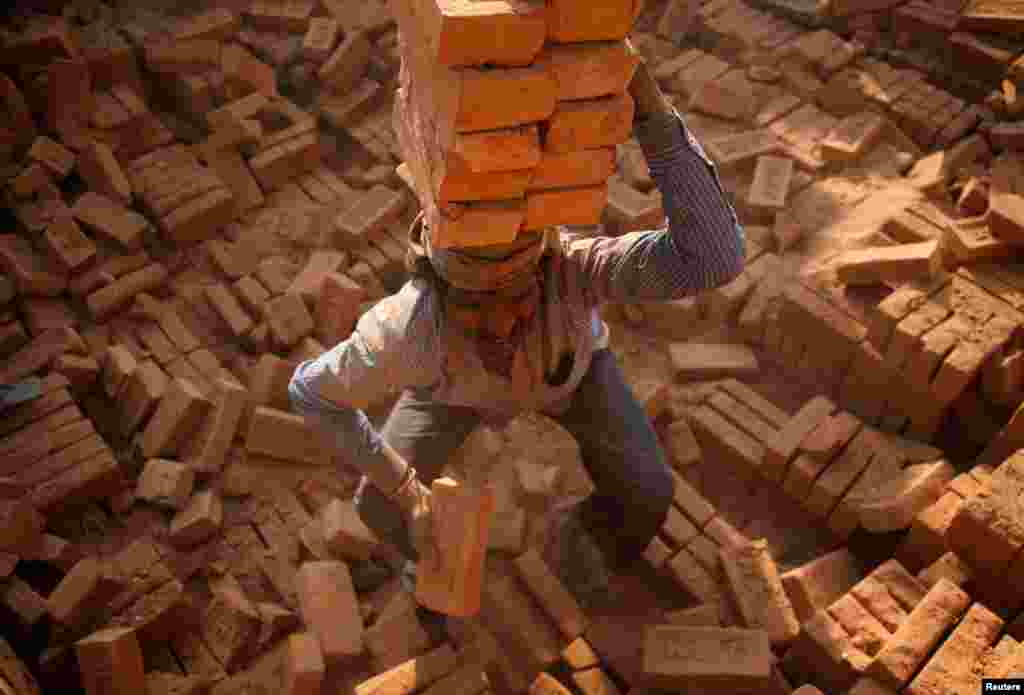 A worker stacks bricks on his head at a brick factory in Bhaktapur, Nepal.