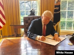 White House Press Secretary Sean Spicer tweeted this photo of President Donald Trump signing a new executive order to ban travelers from six Muslim-majority nations on Mar. 6, 2017.