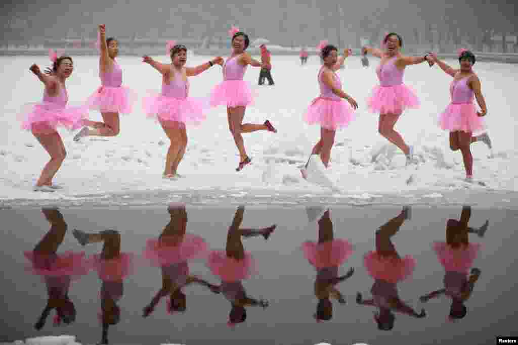 Winter swimmers dressed in ballet costumes pose for a photo before diving into the icy water, during a snowfall at a park in Shenyang, Liaoning province, China.