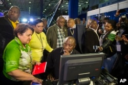 Deputy President Cyril Ramaphosa, seated, and African National Congress party members discuss municipal election results at the results center in Pretoria, South Africa, Aug. 5, 2016.