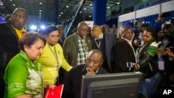 FILE - Deputy President Cyril Ramaphosa, seated, and African National Congress party members discuss municipal election results at the results center in Pretoria, South Africa, Aug. 5, 2016.